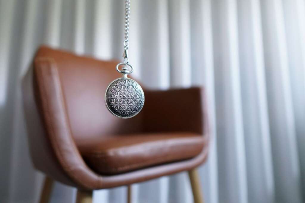 A pocket watch and a leather chair symbolising training in hypnotherapy