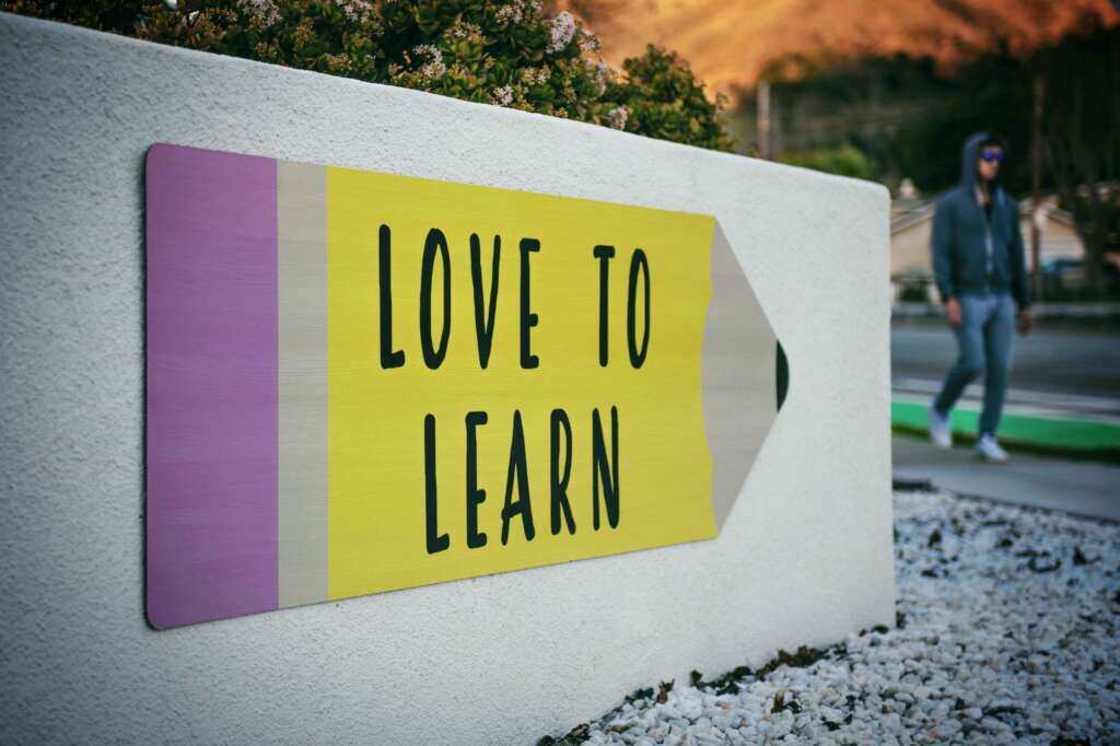 Picture of a white wall with the words written on it saying "Love to Learn"