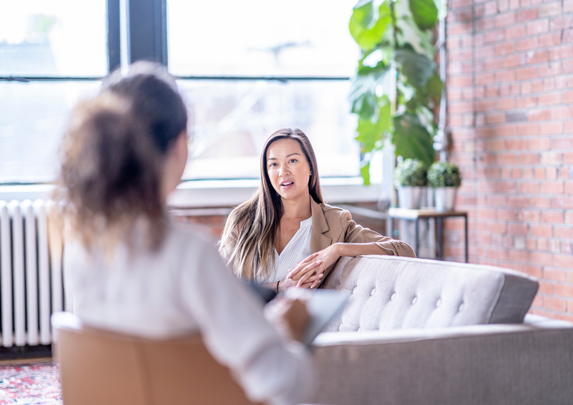 A photo of two people talking in a therapy session