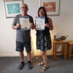 Two students holding their certificates having successfully completed their Intermediate hypnotherapy training